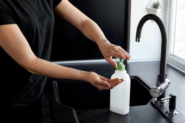 istock woman uses soap for washing her hands on a black kitchen background 1220791603