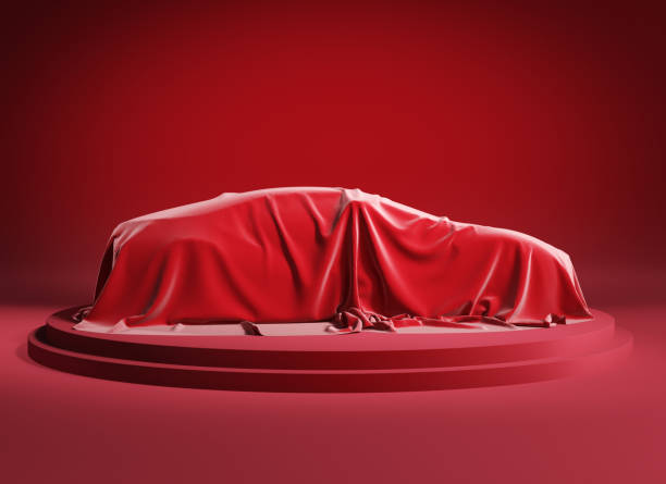 istock Car covered with red silk cloth on a red podium. Isolated with clipping path. 1220792992
