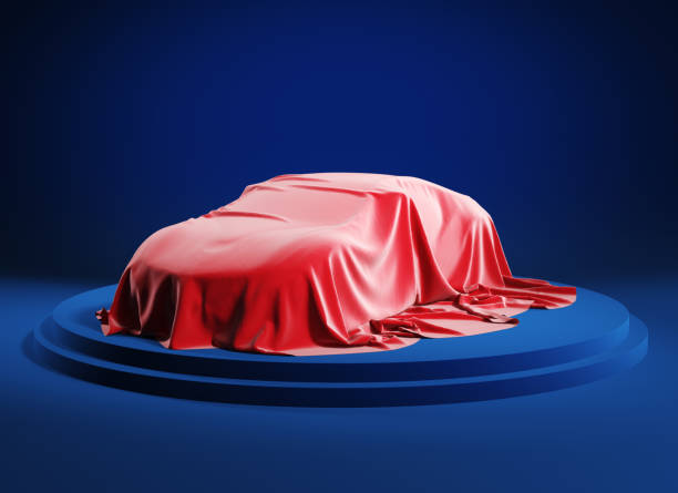 istock Car covered with a red silk cloth before presentation. Clipping path incluted. 1220793040