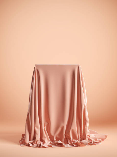 istock Presentation pedestal with pink silk cloth on a pink background. Isolated with clipping path. 1220793200