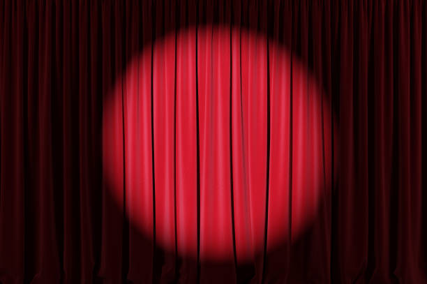istock Background image of red velvet stage curtain with spotlight. 1220793203