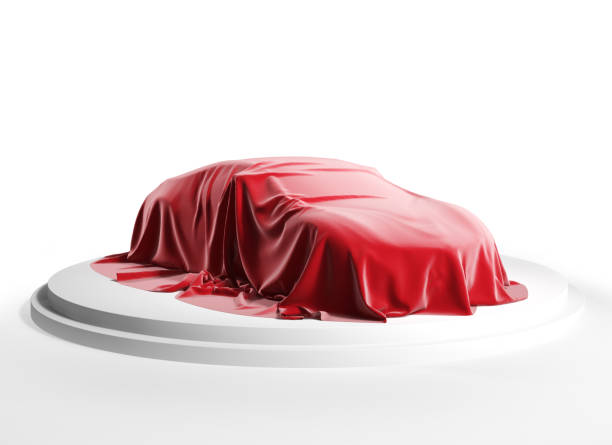 istock Car covered with red silk cloth on a white podium. Isolated with clipping path. 1220793266