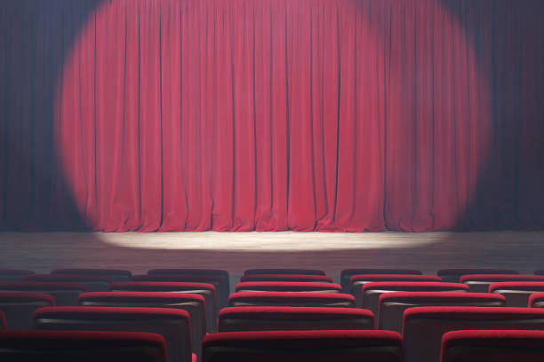 istock Theater stage with red velvet curtains, volume light and smoke. 1220793411