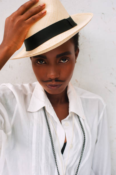 african girl with drawn mustache disguised as a man african girl with drawn mustache disguised as a man, cuba havana style. pimp hat stock pictures, royalty-free photos & images