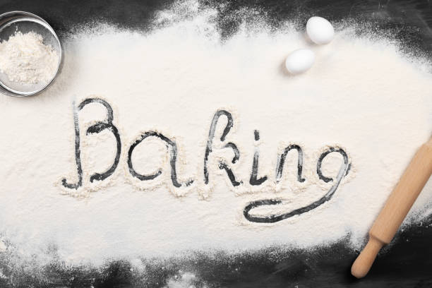 istock Flour is spread on dark table, inscription baking, eggs, rock and sieve for flour 1220795099