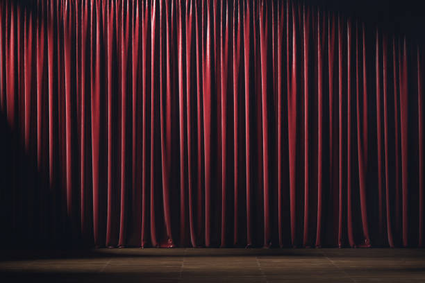 istock Empty theater stage with red velvet curtains and spotlights. 1220795975