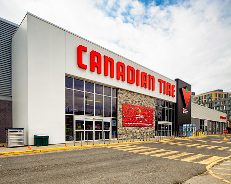 Canadian Tire store facade oblique view on a cloudy Springtime day. Photographed in Montreal on Easter day. This store sells everything for homes and cars and is a Canadian institution.