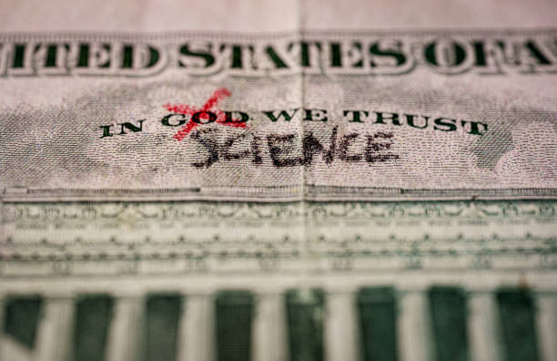 word God crossed out and replaced by science on a US dollar bill stock photo
