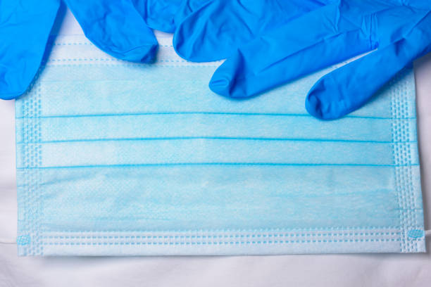istock Blue Gloves on Surgical Mask 1220797224