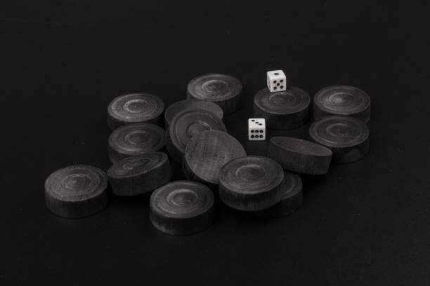 istock Backgammon. Board game. Black chips for playing on  black background. Game for recreation 1220797590