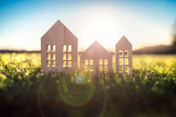 Ecological wood  model house in empty field at sunset Green ecological house in empty field at sunset concept for construction and real estate housing development stock pictures, royalty-free photos & images