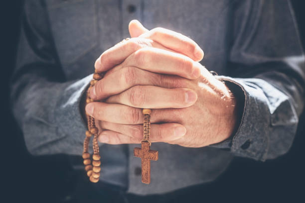 istock Praying hands with crucifix religious cross and rosary beads 1220799689