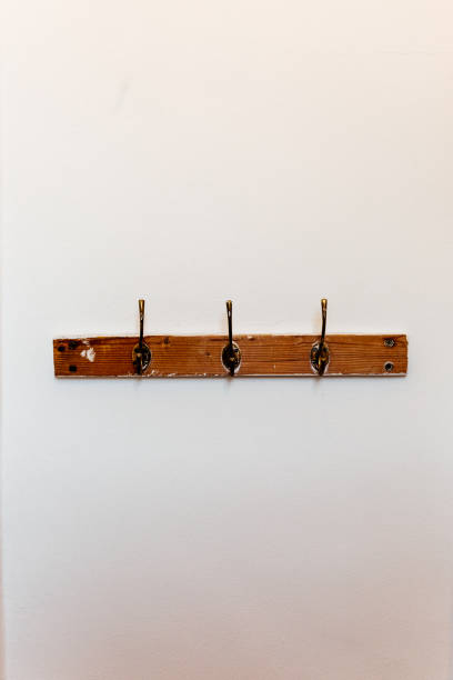 Wooden coat hooks against white wall A portrait image of wooden coat hooks against a white wall coat rack stock pictures, royalty-free photos & images