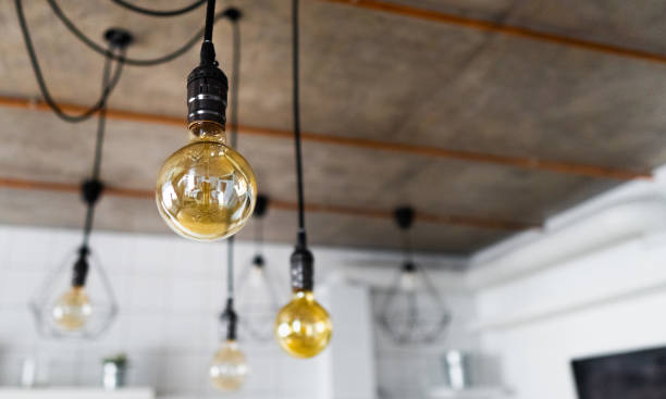 istock Decorative antique edison light bulbs with straight wire. Big vintage incandescent light bulbs hanging in modern kitchen. Inefficient filament light bulbs waste electricity. Dimmable, warm white, E27 1220802733