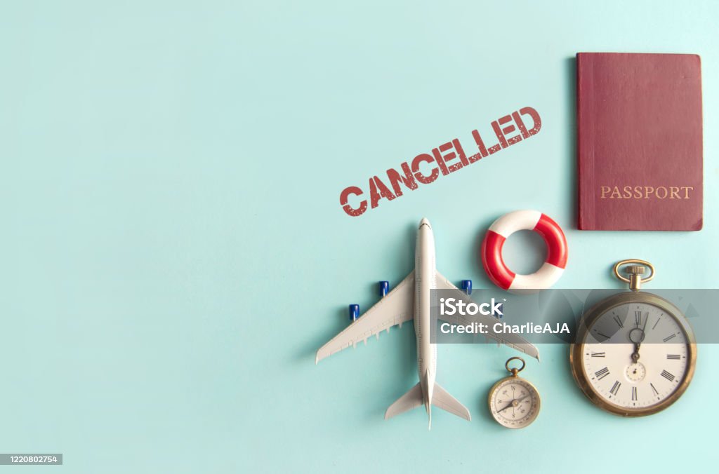 Travel cancellations Cancelled stamped by travel assessories including miniature airplane, clock and passport with space Cancellation Stock Photo