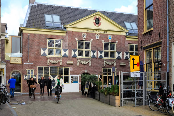 Delft, The Netherlands - October 10, 2019: A front view of the building which is known as the historic site of the former St. Lucas Guild. Nowadays here is located The Vermeer Centrum Delft. Delft is a popular tourist destination. Many tourists come here and find in this city a summary of the architecture, art and landscape of the Netherlands. Many historical buildings have been preserved in the old part of the city. There are many narrow streets and many of them are canals, the banks of which are connected by small bridges. The city is known for its connections to art, culture and science.