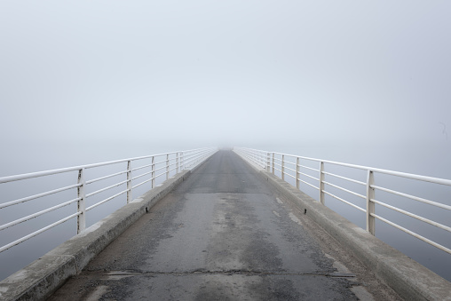 Foggy bridge view from Ellendale Road Bridge on Meadowbank Lake with mist in winter, Ouse, Tasmania, Australia