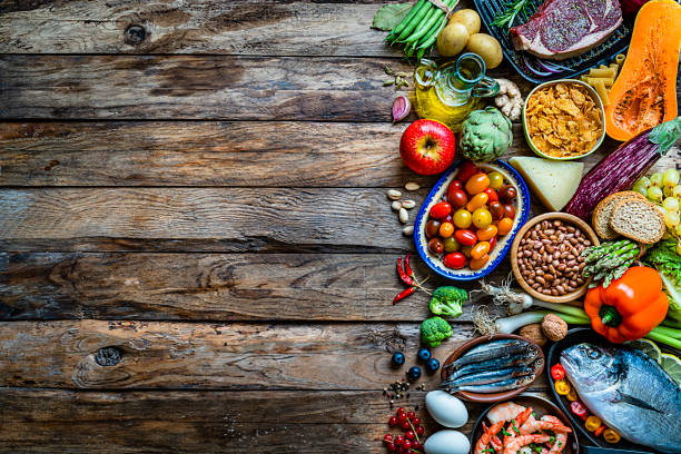 sfondi alimentari: grande varietà di cibo su tavolo rustico in legno. spazio di copia - artichoke food vegetable fruit foto e immagini stock