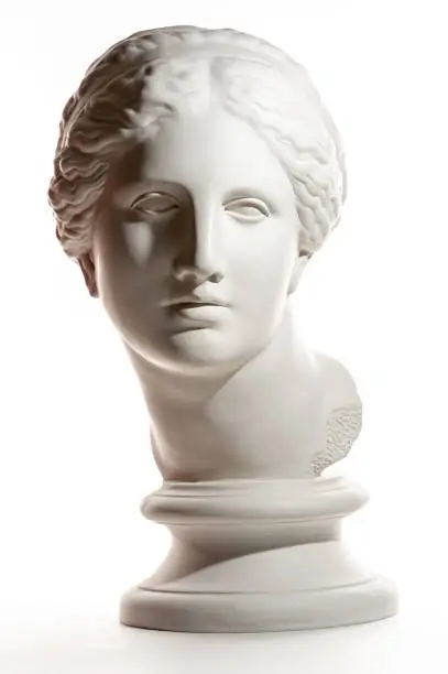 White gypsum copy of ancient statue of Venus de Milo head for artists on a white background. Plaster sculpture of woman face.