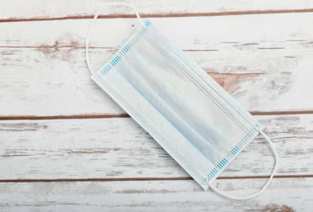 istock Medical protective mask on wooden texture for background 1220810394