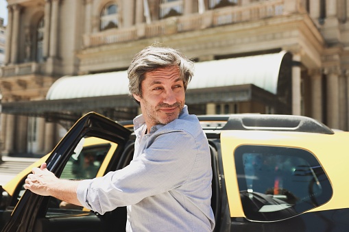 Caucasian businessman getting off the taxi in Buenos Aires