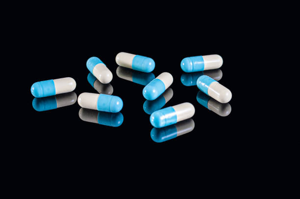 istock White and blue two halves capsules on an isolated black background with reflection 1220815400