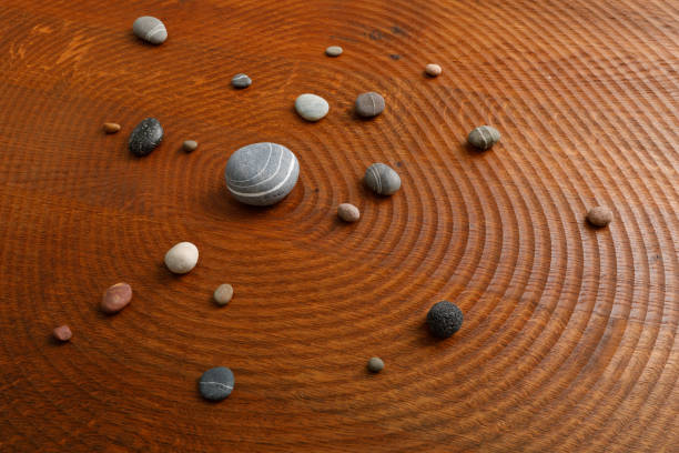 Pebbles arranged in an orbit on a wooden plate