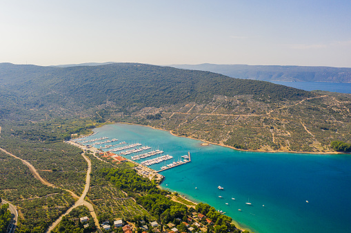 Idyllic scene with aerial view of the coastline of Adriatic Sea with lots of boats in a marina,  Cres Island,  Croatia