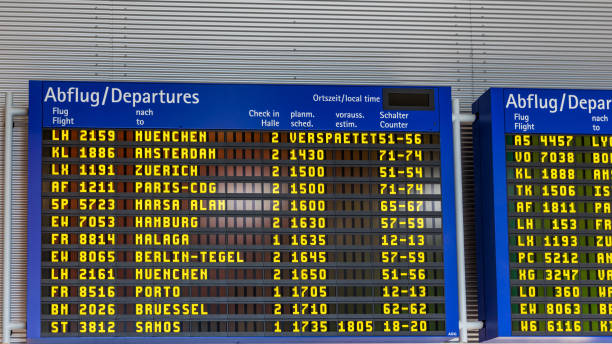 istock Airport flight information displayed on departure board, flight status changing. Flight schedule screen at airport showing different destinations. 1220818151