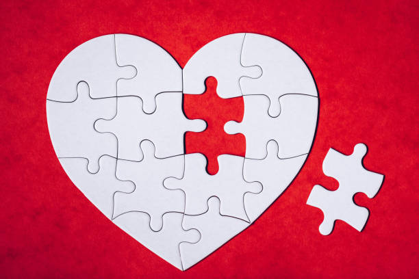 istock Heart-shaped jigsaw puzzle on color background. Puzzle heart on wooden background. A missing piece of the heart puzzle. Heart shape jigsaw puzzle. Puzzles in the shape of a heart. 1220818166
