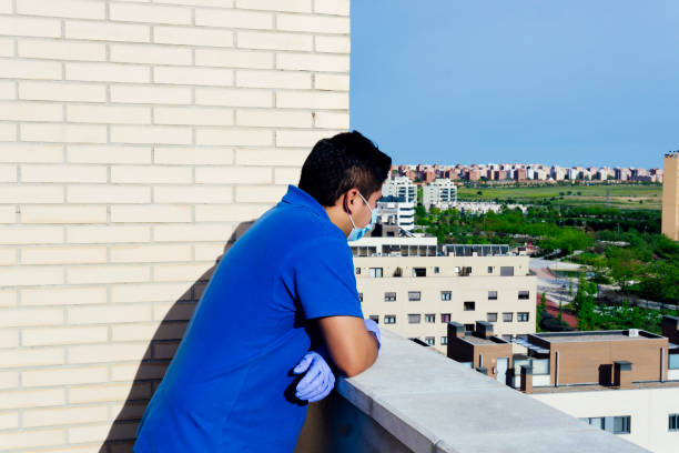 istock coronavirus. person in quarantine on their terrace using protective measures 1220819216