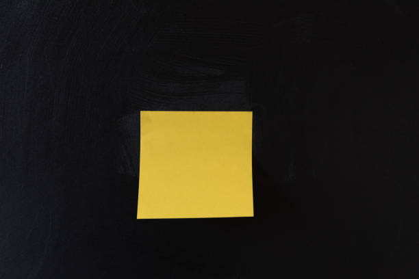 istock A sheet of yellow sticker pasted on a black background. Space for text. reminder concept. 1220825438
