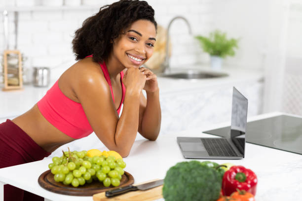 istock Afro girl using laptop searching recipes looking at camera 1220825918