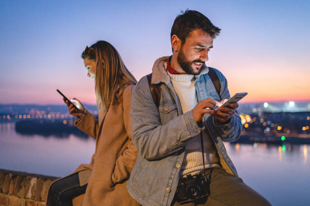 istock Smiling tourists using cellphones 1220826153