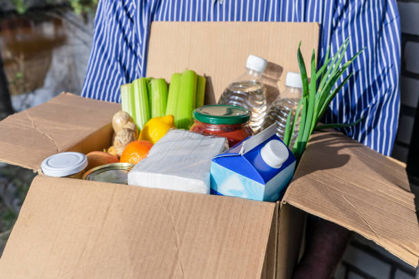 istock A man holds a box with groceries. Home delivery concept. 1220826226