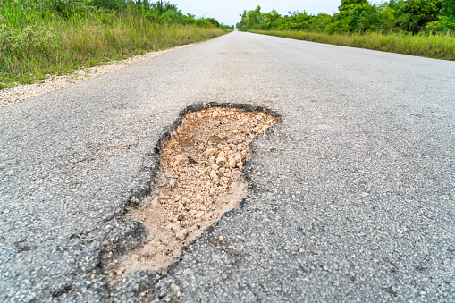 Photograph of a hole in an asphalt road Zanzibar,  Tanzania