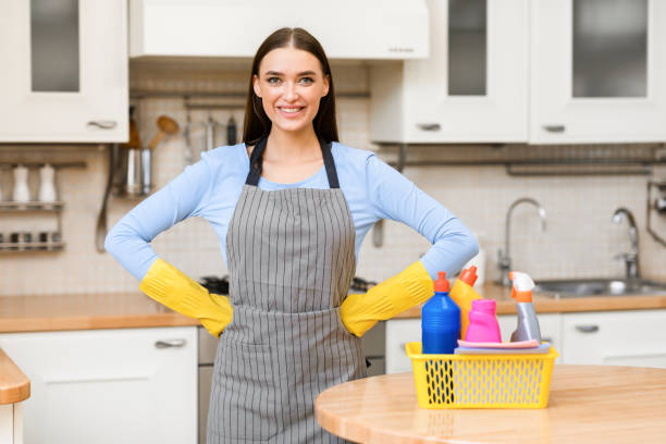 istock Smiling woman standing in kitchen with detegents 1220828878
