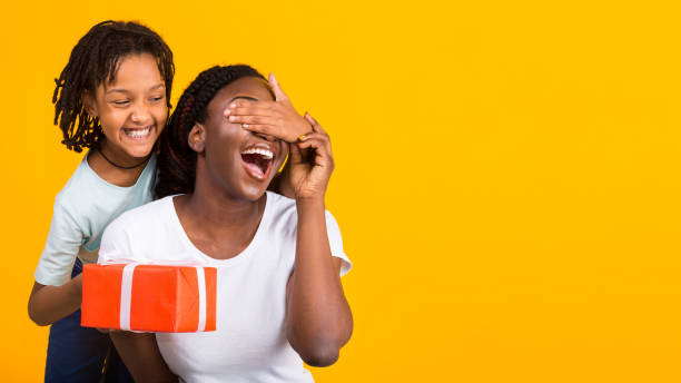istock Black girl congratulating her mom at yellow studio 1220829612