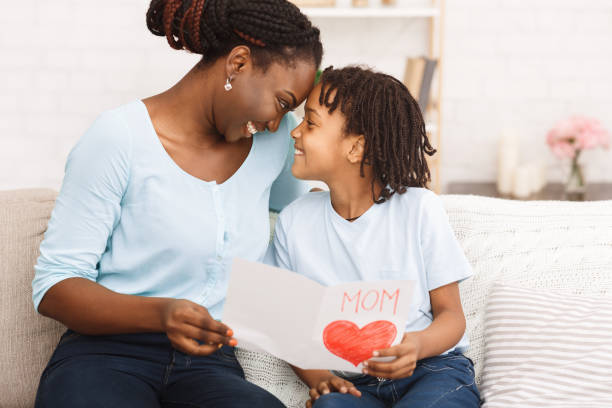istock Afro kid congratulating her mom on the couch 1220829641