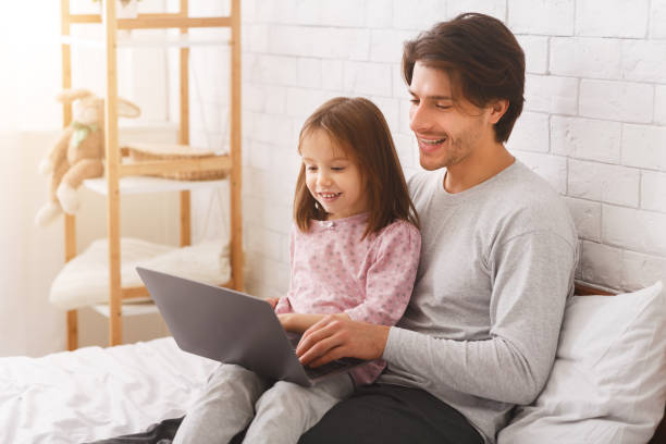 istock Little girl spending time with her dad, using laptop 1220829689