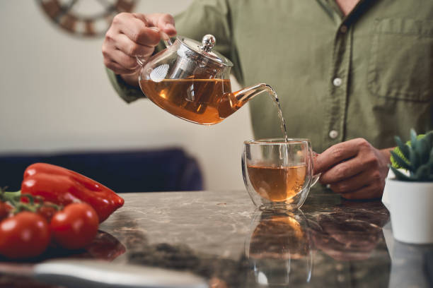 istock Man at the marble countertop making tea 1220830449