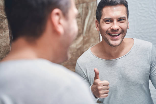 istock Man admiring his looks in the mirror 1220830504
