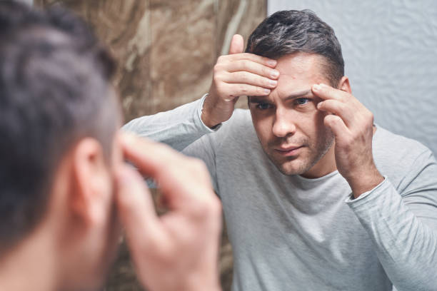 istock Male looking at himself in the mirror 1220830505