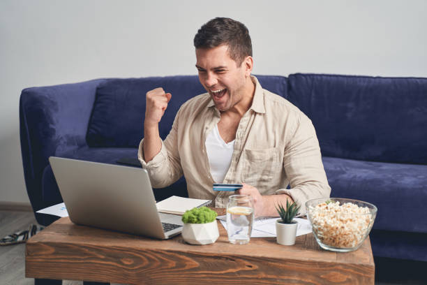 istock Happy man sitting in front of his laptop 1220830580