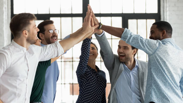 istock Overjoyed diverse colleagues give high five celebrating success 1220833355