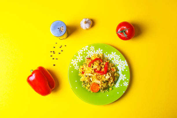Rice with vegetables in white plate on wooden cutting board