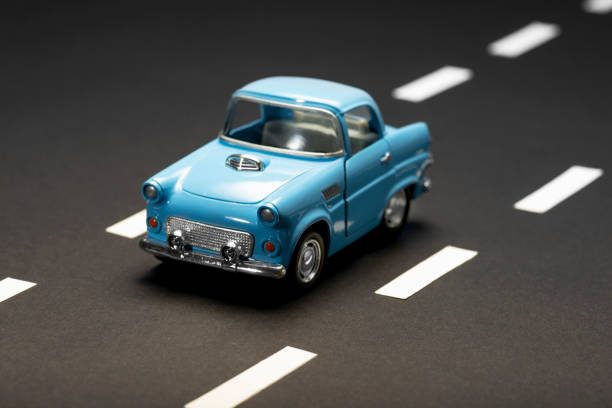 Blue toy car on an asphalt road.