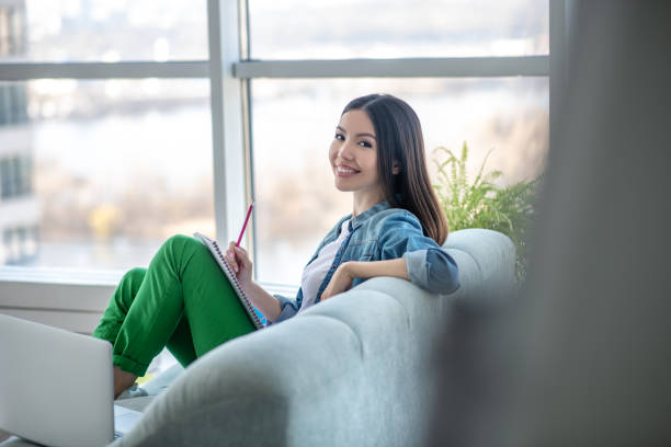 istock Young woman in a jeans jacket sitting on the sofa and feeling great 1220834754