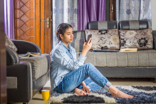 an indian teenage girl with mobile phone - homework teenager mobile phone school imagens e fotografias de stock