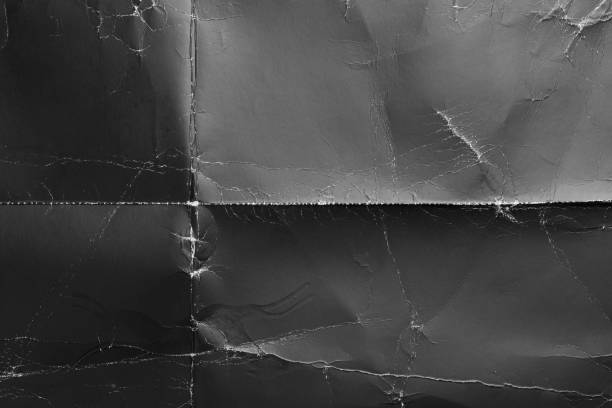 Wrinkled black old wrinkled paper. Dusty cardboard wrapping